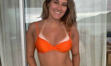 Filha de Fátima Bernardes posta foto de biquini laranja e marquinha do bronzeado