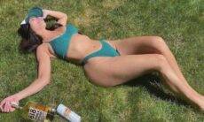 Kim Kardashian posa de biquíni deitada na grama curtindo dia de sol